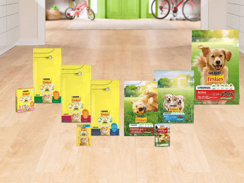 Asortiman Friskies hrane za pse i mačke na drvenoj površini na podu
